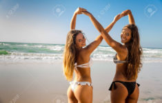 beautiful girls in the beach giving her hands together stock photo